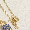 Détails du collier doré avec pendentifs cadenas à carreaux bleu et petite clé - Collier Serrure et Clé Surface Lisse