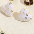 Macro shot of white enamel heart stud earrings with golden flower accents and metal pins - White Heart Enamel Stud Earrings (ES2337-1)