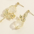 Gros plan sur des boucles d'oreilles rose avec feuilles dorées et pétales en résine blanche - Boucles d'Oreilles Rose (ES2347-5)