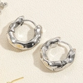 Macro shot of silver Cuban chain earrings with lava texture and irregular metal surface - Silver Irregular Hammered Hoop (ES2348-1)