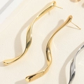 Close-up of polished gold wavy earrings with 925 silver needles on a textured background - Shiny Gold S-shaped Long Curve Style
