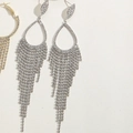 Close-up of elegant silver tassel earrings with shimmering rhinestones and flower details - Water Drop Claw Chain Tassel Earrings