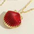 Macro shot of a red shell pendant with golden metallic texture and an O-style chain - Red