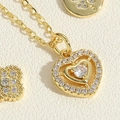 Macro detail of gold-plated heart pendant with sparkling crystals and clover element - Double Heart Zirconia Necklace (MA1-8) / Gold