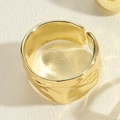 Detail eines breiten Goldrings mit gehämmerter Textur und verstellbarem offenem Design - Gehämmerter Strukturstil