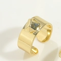 Detailansicht eines breiten vergoldeten Rings mit grauem geometrischem Steinbesatz - Unregelmäßiger Geometrischer Stil