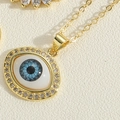 Macro view of gold devil's eye pendant necklace with blue iris and sparkling zircon stones - Pave White Zircon Oval Style