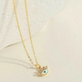 Détail du collier pendentif œil maléfique avec cils en zircone sur fond de pierre - Mauvais Œil Blanc