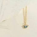 Détail du pendentif œil maléfique doré avec émail bleu et cils scintillants en zircone - Œil maléfique bleu royal