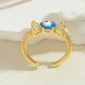 Macro-opname van gouden evil eye ring in snoepvorm met fonkelende zirkonia-steentjes - Blauw Emaille (JZ0347-4)