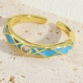 Detailopname van de verstelbare gouden ring met blauw emaille en fonkelende zirkoon - Blauw
