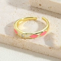 Detail macro-opname van een roze en wit geruite emaille ring met een zirkonia steen - Dieproze
