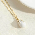 Macro detail of white enamel waterdrop pendant with gold stripes and zircon stones - White