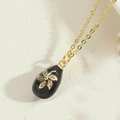 Golden cross chain necklace featuring a black teardrop pendant with gold flower and zircon - Black