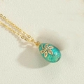 Vintage style golden necklace with a teal enamel egg pendant and zircon flower detail - Lake Blue