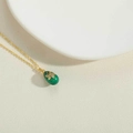 Vintage golden necklace featuring an emerald green egg pendant with floral zircon inlay - Green