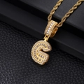 Macro view of gold-plated letter G pendant with cubic zirconia on a twist chain - Letter G / Gold