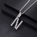 Macro shot of silver-colored iced out letter M pendant with zircon stones and rope chain - N-Silver