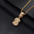 Close-up of golden letter S pendant with white zircons on rope chain in a black gift box - Letter S / Gold