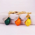 Sparkling lemon fruit keychains with rhinestones in green, orange, and yellow colors - Random Color