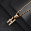 Close-up of golden letter H pendant necklace with baguette-cut zircons and rope chain - Letter H (5507837524619)