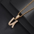 Macro shot of gold letter U pendant with baguette zircons on a black jewelry box - Letter U (5507837524632)