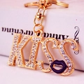 Gouden KISS sleutelhanger met witte strassteentjes en paarse lippenhanger - Enkele OPP-zak / Zwart