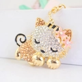 Cute rhinestone sleeping cat keychain with pink flower details in gold metal finish - Champagne