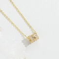 Dettaglio collana d'oro con pendente cilindrico con zirconi e cuori incisi - Cuore d'Oro