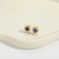 Detailaufnahme goldener Sonnenblumen-Ohrstecker mit blauem Zirkon und Pavé-Rand - Saphirblau (Gold)