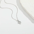 Minimalistische silberne Halskette mit Anhänger Nummer 9 und Wabenmuster auf weißem Stein - Zahl 9
