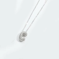 Macro shot of silver letter C pendant with micro-paved crystals on a delicate chain - Letter C