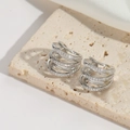 Elegante ear cuff plateado multicapa con circonitas brillantes sobre piedra travertino - Estilo Pavé Hueco de Varias Capas / Plateado