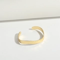 Detailed close-up of a minimalist C-shaped gold bracelet with hammered texture finish - Bangle SL3472-5