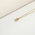 Elegant gold cross necklace with red and white zircons on a minimalist beige background - Windmill