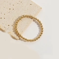Minimalistische elastische armband met gepolijste gouden kralen op stenen achtergrond - Ca. 0.6cm Kraaldiameter / Goud