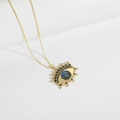 Macro shot of gold-plated Devil's Eye pendant with blue inlay and sparkling zircons - Royal Blue Eye