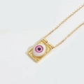 Detailed 45-degree angle view of vintage gold Devil's Eye pendant with purple inlay - Pink