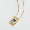 Macro detail of retro golden square pendant necklace with blue devil's eye design - Gray