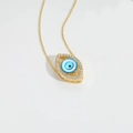 Detailed close-up of golden Evil Eye pendant necklace with blue eye and zircon inlay - White