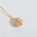 Detail of pink vintage egg pendant with gold vine relief and zircon inlay work - Pink