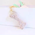 Sprankelende sleutelhanger in de vorm van een bot met witte steentjes en een gouden sluiting - Gewicht 32,9g, Lengte 11,2*2,1CM / Goud Met Witte Strass
