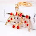 Golden bat keychain charm featuring white rhinestones and sparkling ruby accents - Red