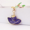 Elegante portachiavi a forma di cappello dorato con strass blu scuro e moschettone - Blu scuro