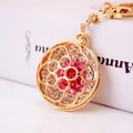Exquise gouden bloem sleutelhanger met roze en rode strass-steentjes op witte achtergrond - Rood