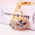 Goldener Handtaschen-Schlüsselanhänger mit weißen Kristallen und blauer Blume - Grau