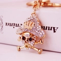 Portachiavi teschio pirata dorato con strass scintillanti e corona su libro vintage - Bianco