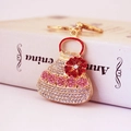 Portachiavi borsa dorata con cristalli rosa e fiore rosso su un libro bianco - Bianco