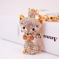 Sparkling crystal cat keychain with golden crown and champagne bow tie accent - Peach