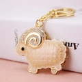 Charming golden ram keychain with white enamel, rhinestones and elegant spiral details - Individual OPP Bag Packaging / White